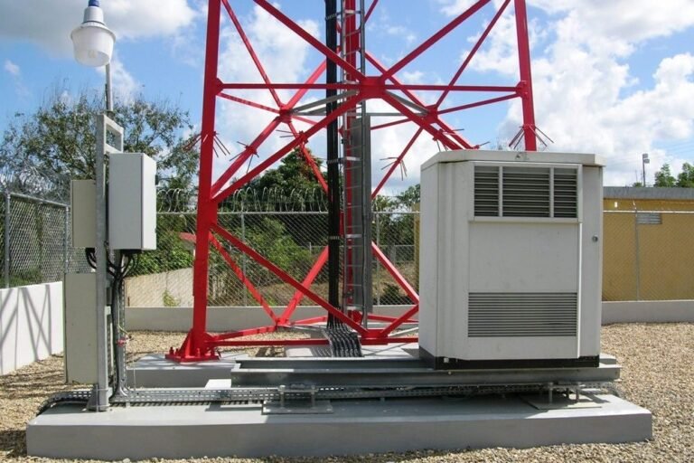 Rural cell tower facility surrounded by chain-link fencing